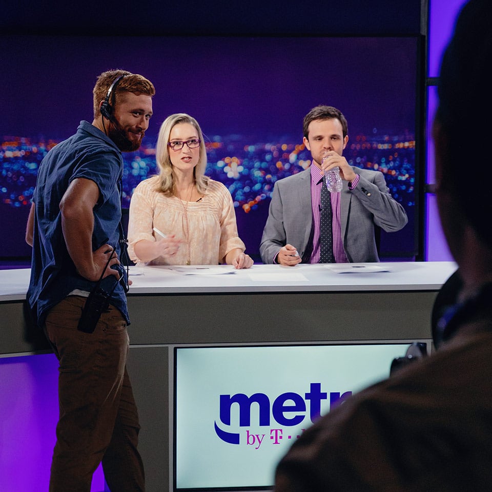 Actors playing news anchors for a wireless company commercial