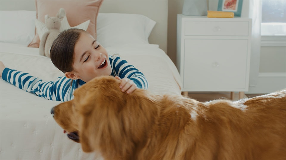 A color graded shot of a child and dog in a product demo commercial