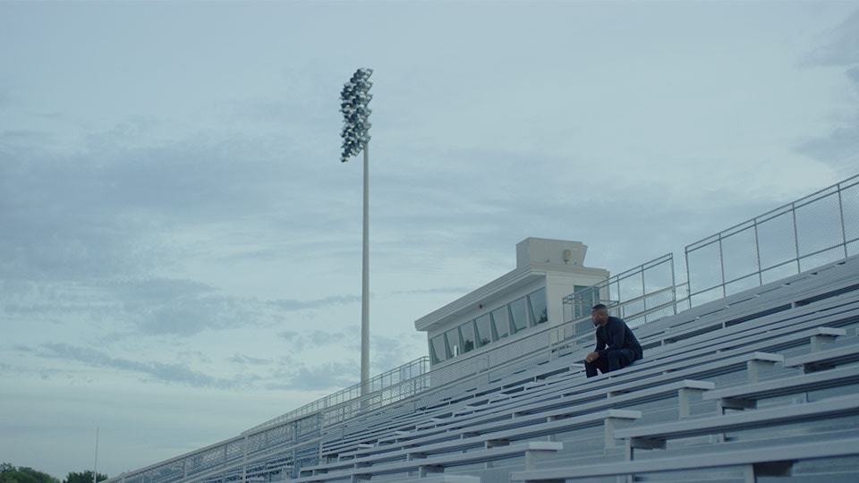 A shot of a athlete sitting on a bleacher from a branded documentary style video