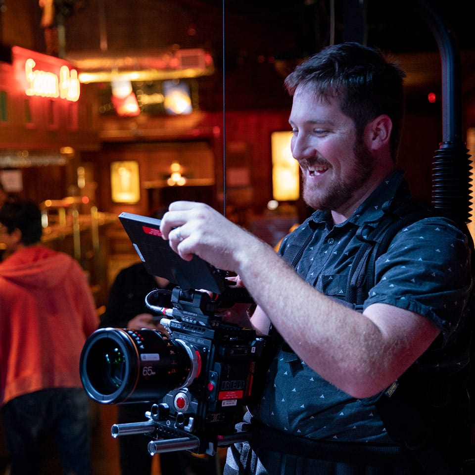 A camera operator holding a digital cinema camera